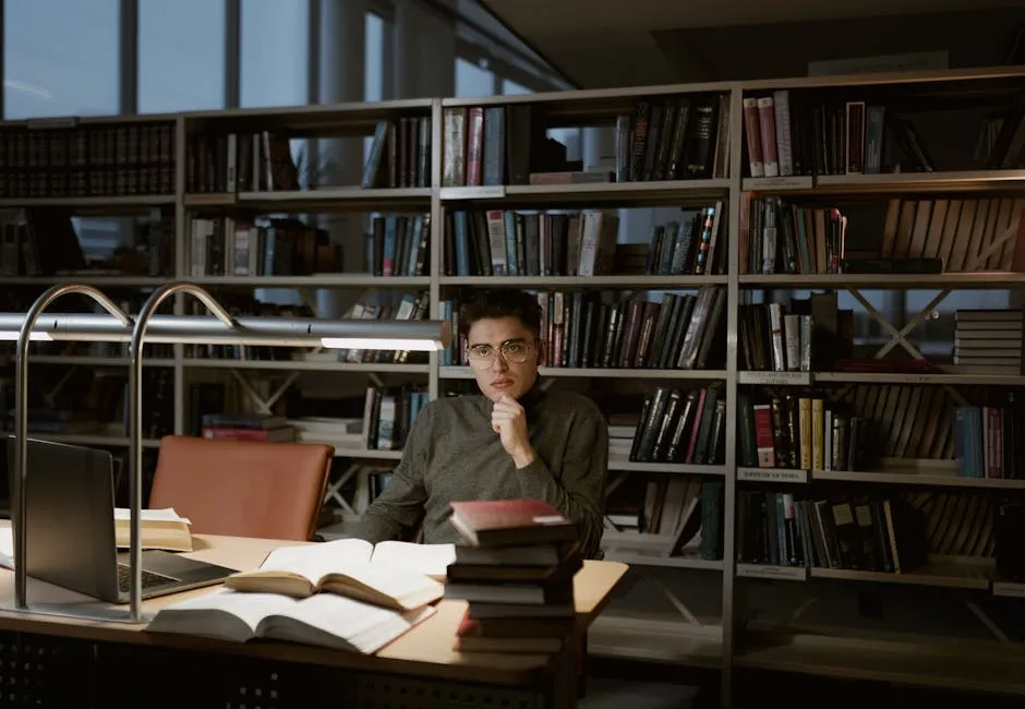 Pessoa concentrada escrevendo em uma mesa com livros e café, representando pesquisa acadêmica profunda