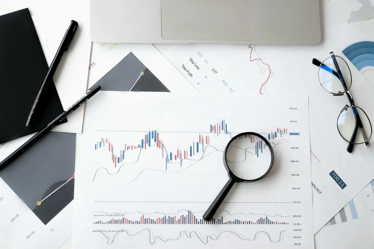 Pessoa analisando dados estatísticos em planilha com calculadora ao lado