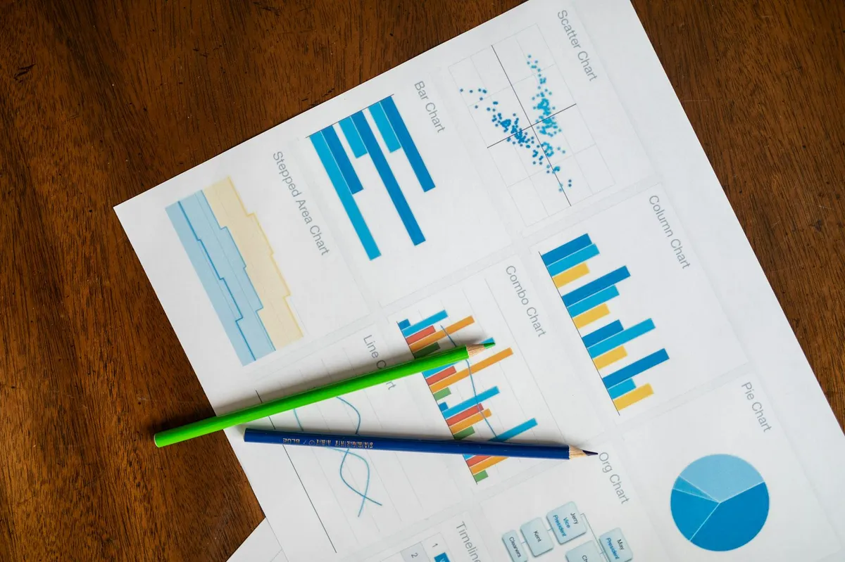 Pesquisador analisando gráficos e dados em mesa de trabalho acadêmico