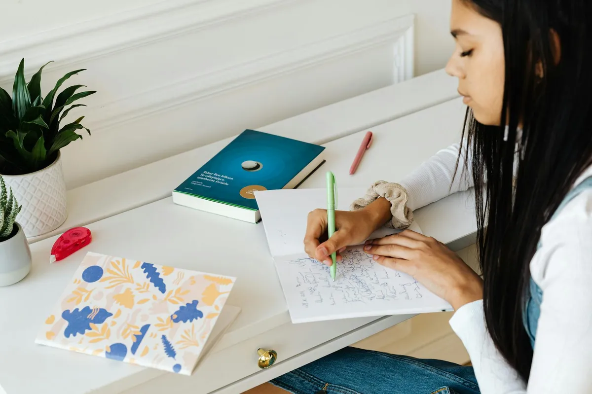 Estudante de psicologia estudando livros e anotando para o TCC