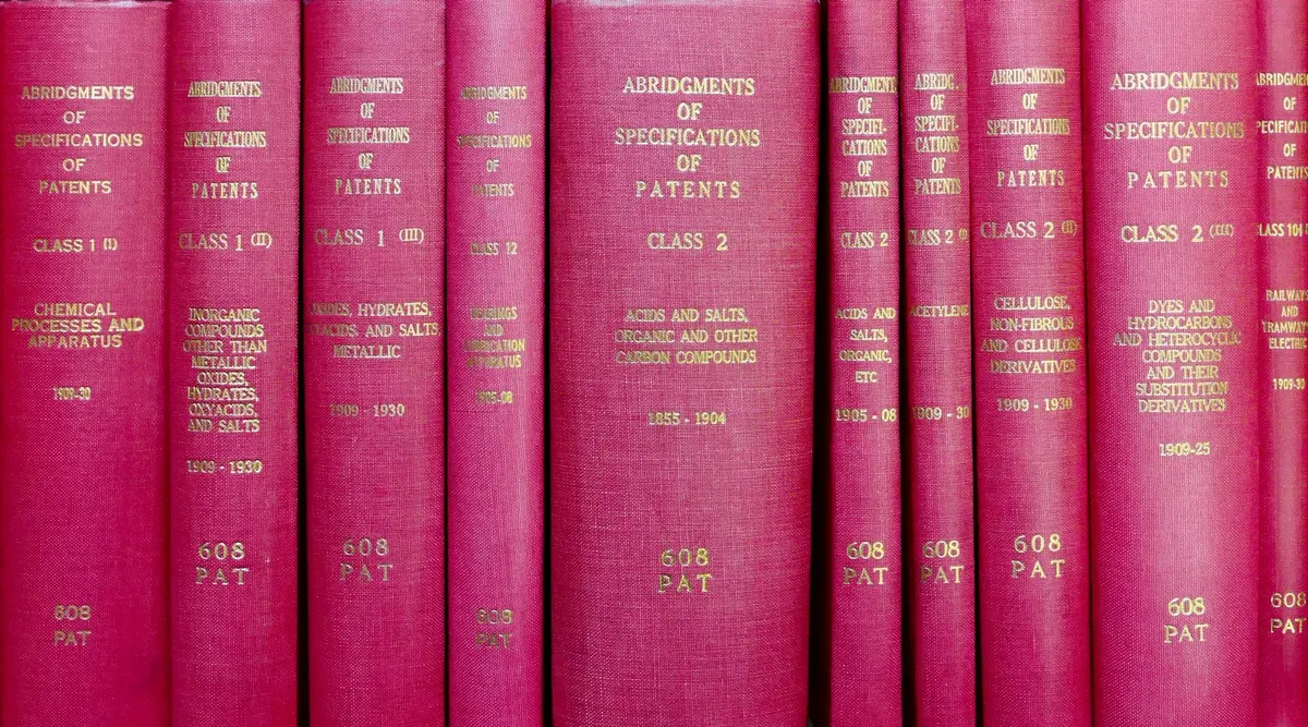 Lista de referências bibliográficas em documento acadêmico com livros empilhados ao fundo