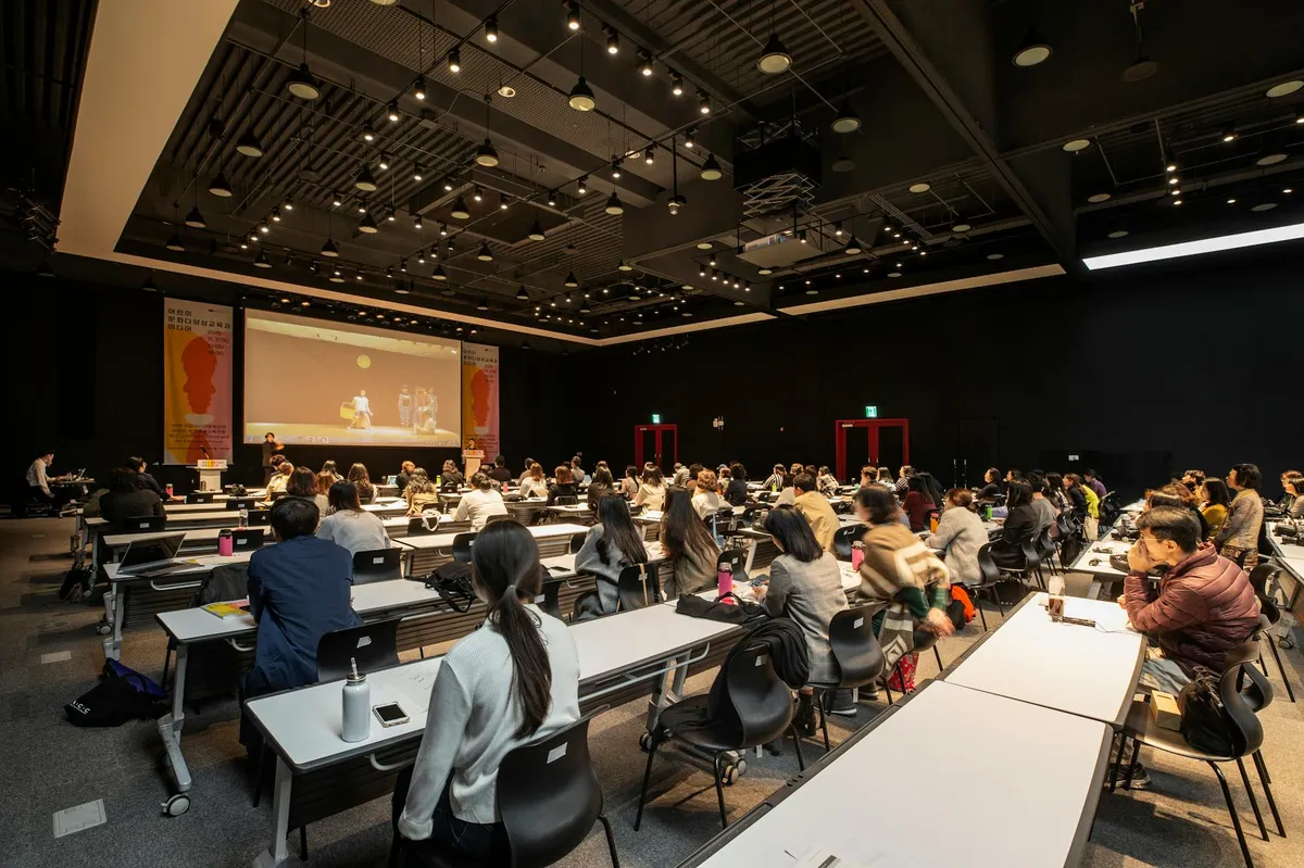 Mesa de debate acadêmico com pessoas conversando em auditório universitário