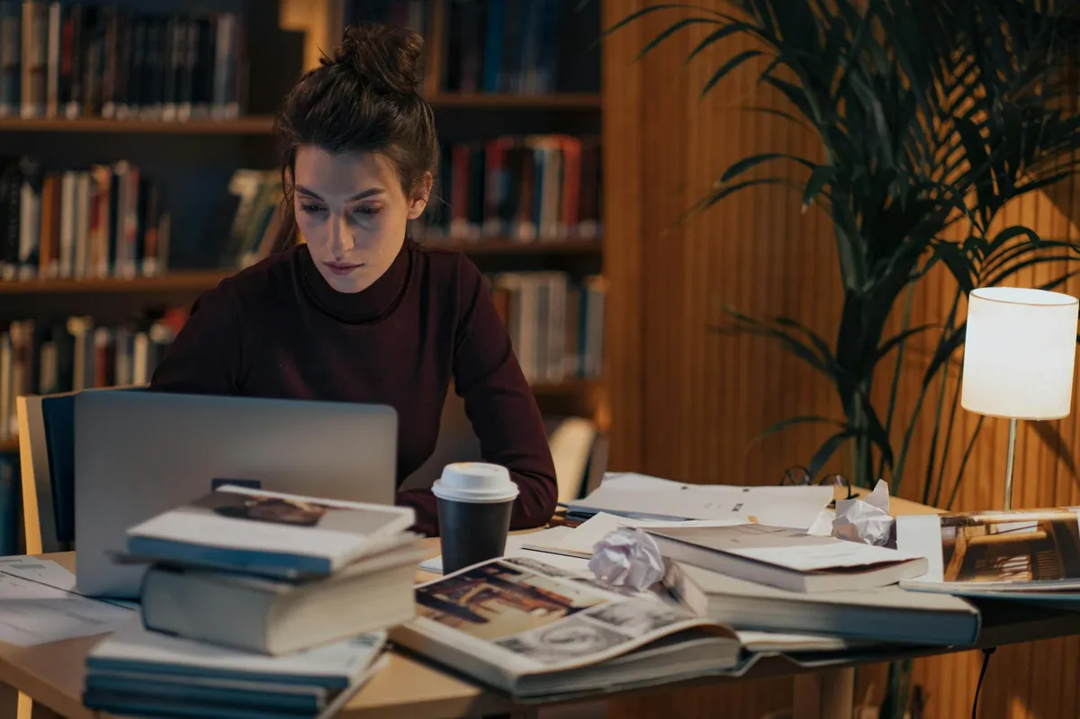 Pesquisadora comparando artigos científicos na tela do computador durante revisão de literatura