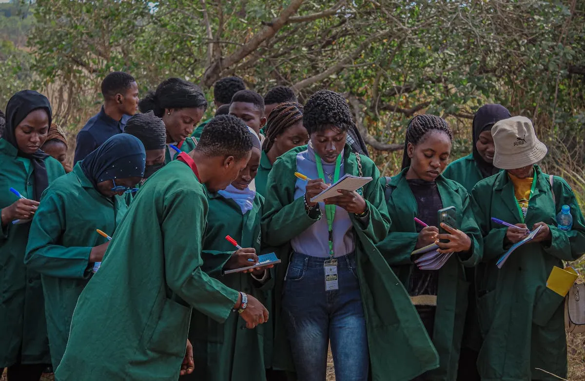 Pesquisadora anotando observações de campo em caderno durante trabalho qualitativo