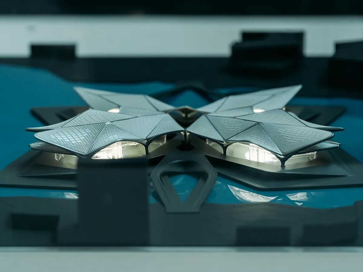 Pesquisador construindo e testando protótipos em ambiente de laboratório com esquemas na parede