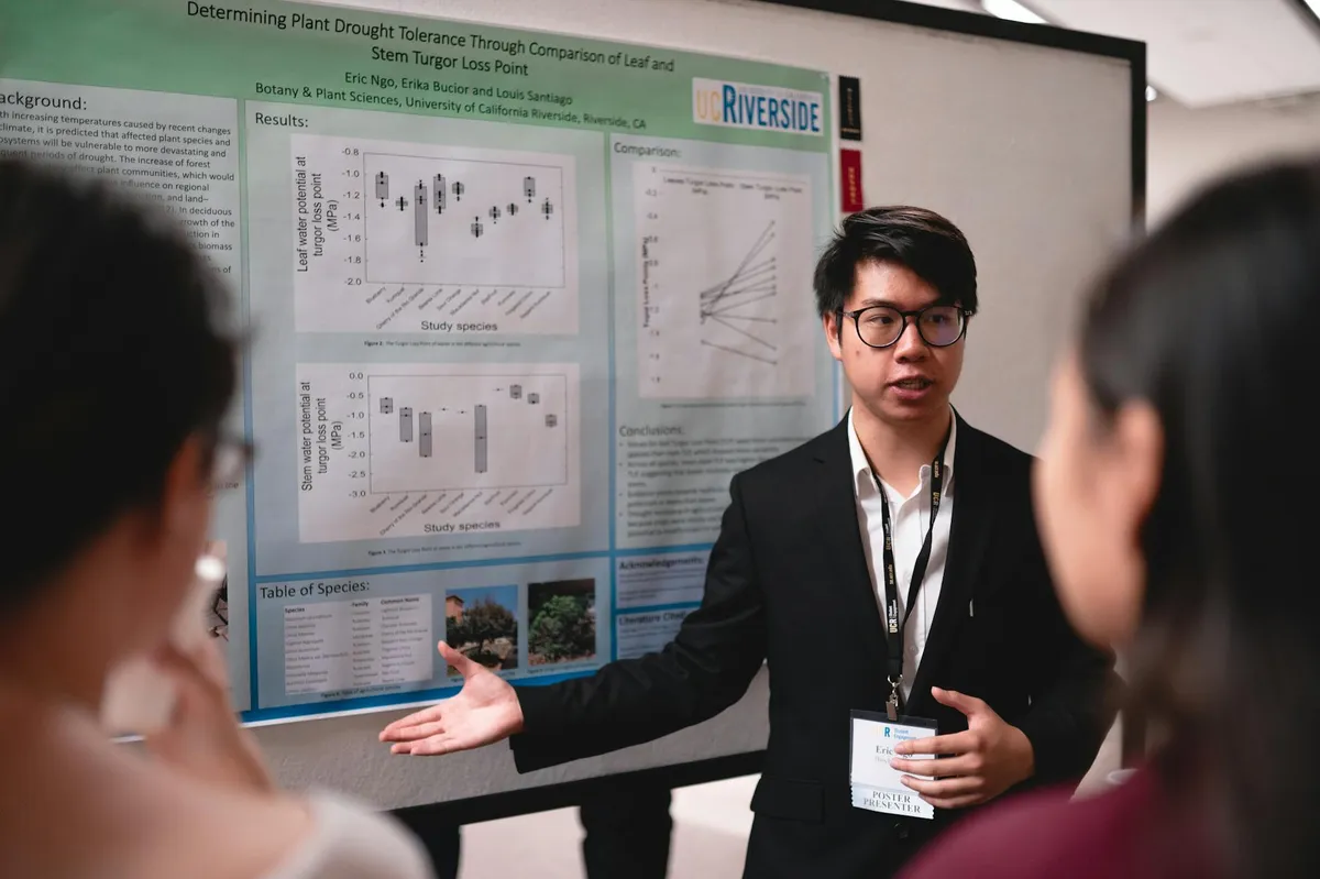 Estudante apresentando trabalho em frente a professores em sala de aula universitária