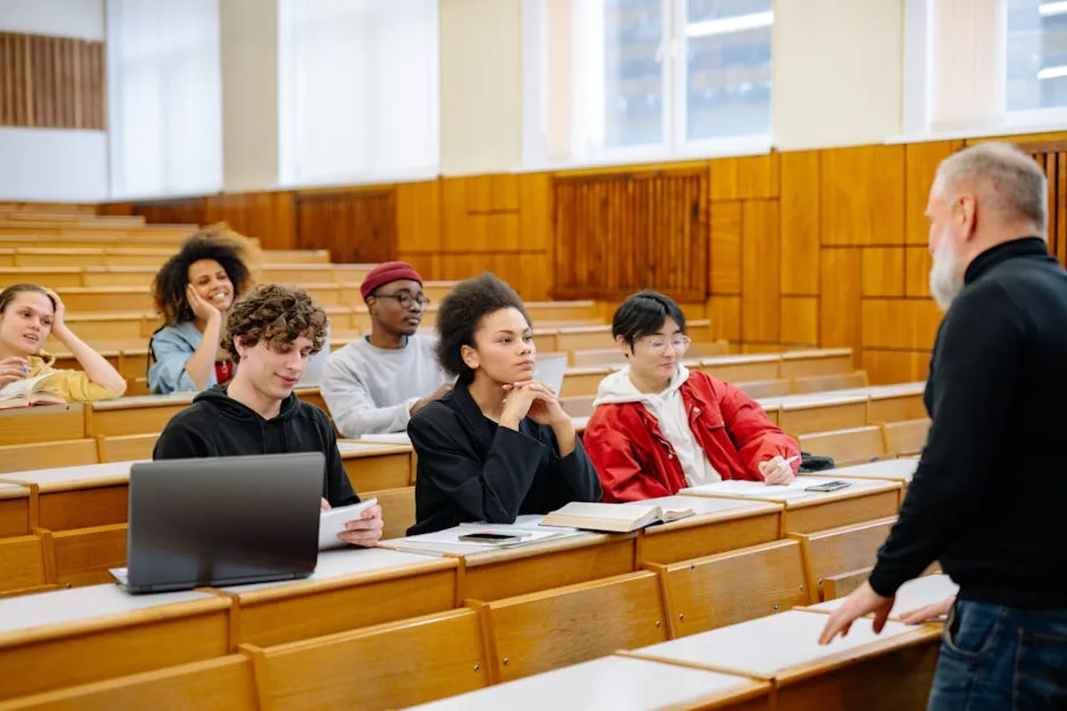 Sala de aula universitária com professores e estudantes em encontro presencial