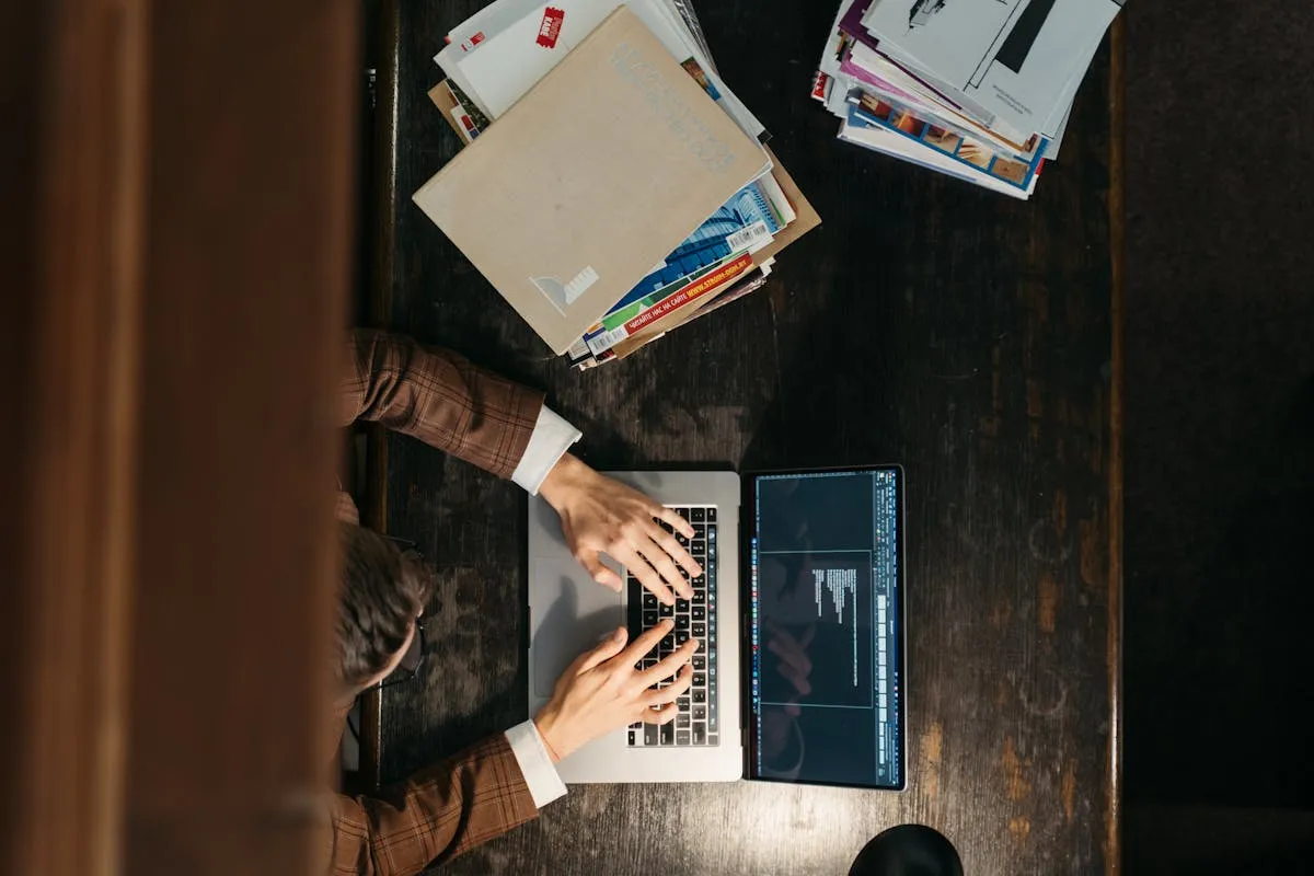 Documento acadêmico formatado aberto em computador com régua e caneta ao lado