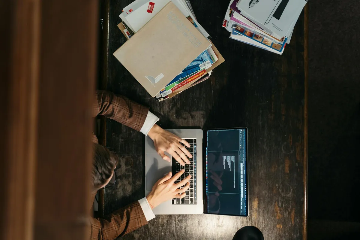 Pessoa usando computador para formatar documento acadêmico com ajuda de inteligência artificial