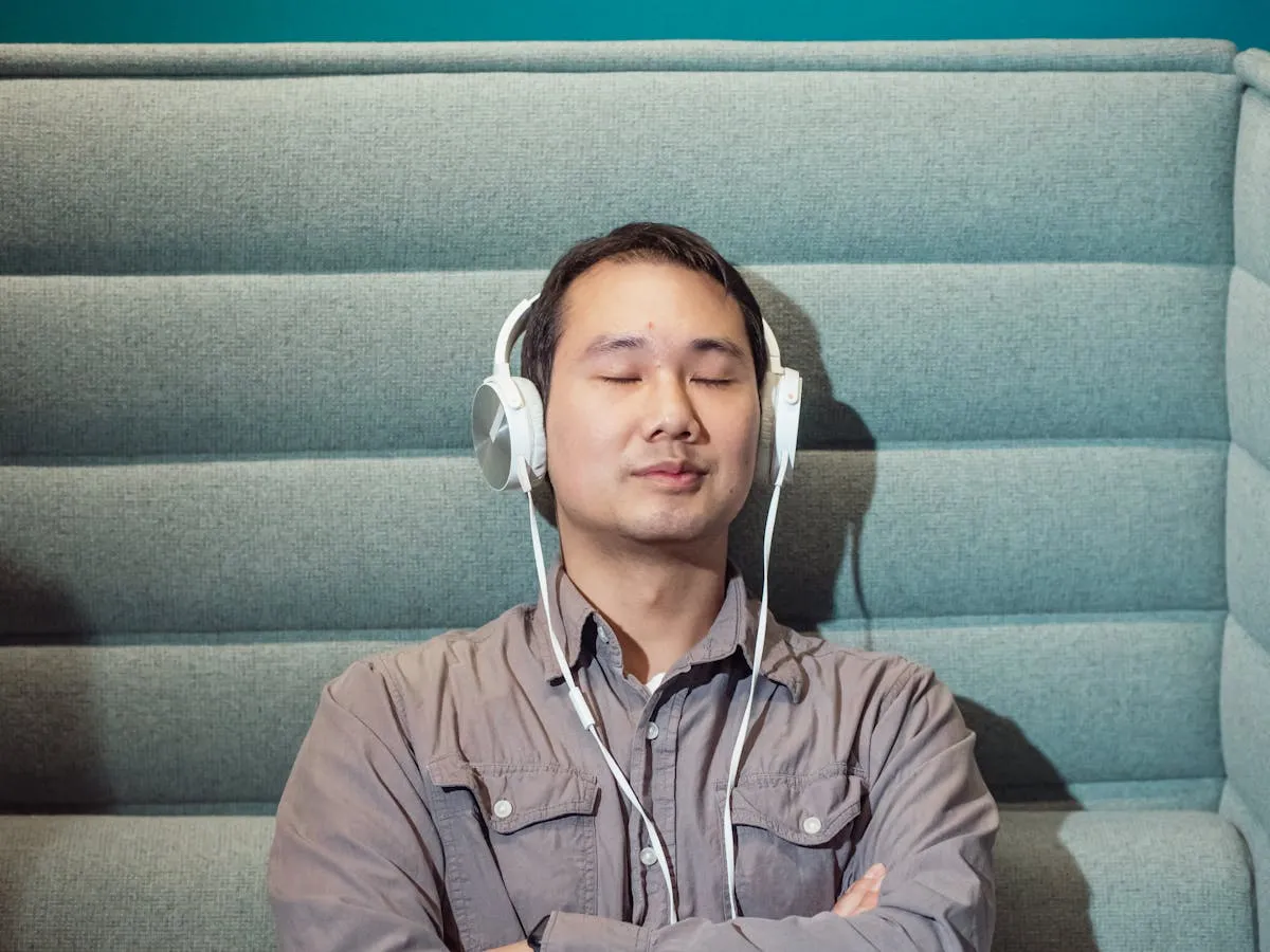 Pesquisadora ouvindo gravação de entrevista com fones de ouvido, computador com transcrição na tela