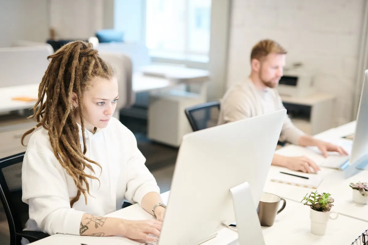 Estudante escrevendo relatório de estágio em notebook em ambiente de trabalho