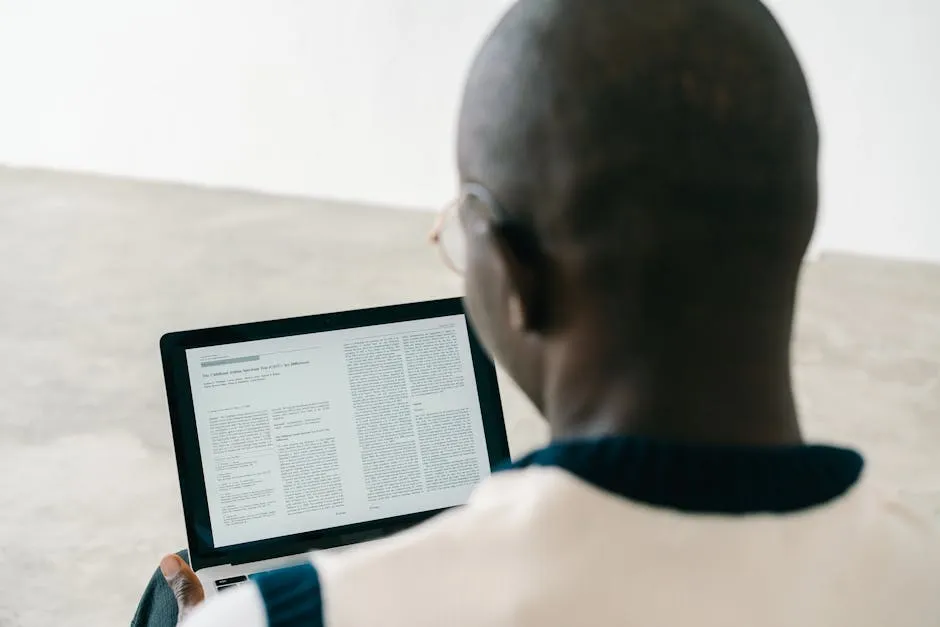 Pessoa lendo artigo publicado em tela de computador com expressão satisfeita