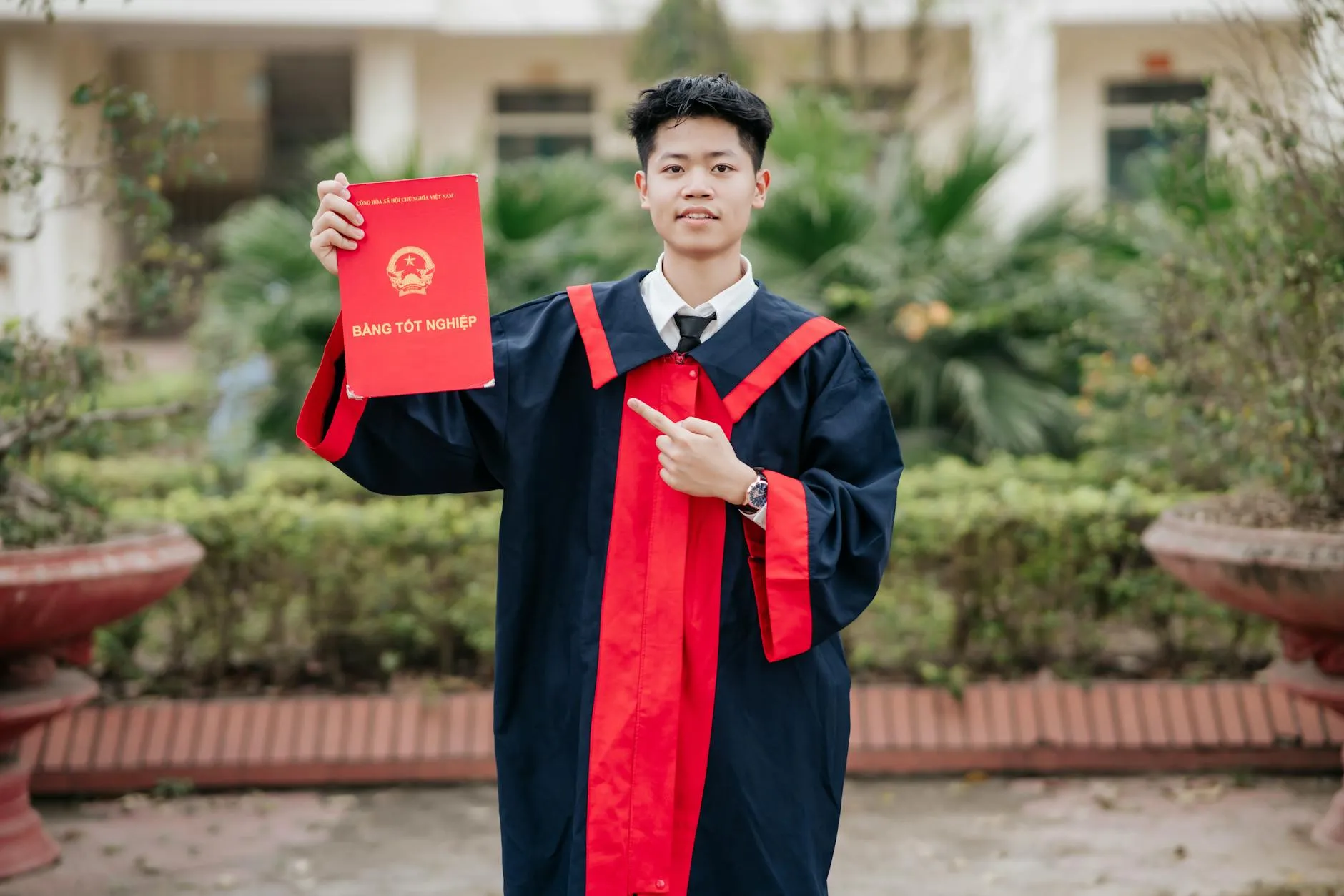 Mestranda sorrindo após defesa de dissertação com diploma em mãos