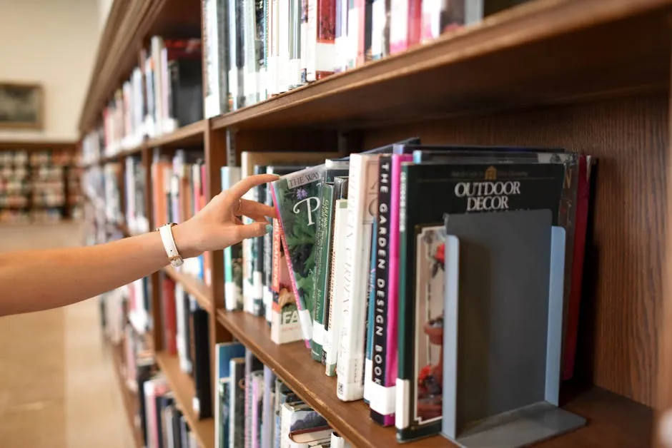 Estante com livros acadêmicos coloridos e mesa de estudo ao fundo