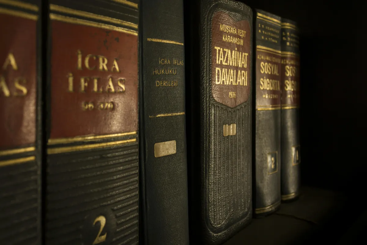 Livros de direito e caderno sobre mesa de madeira com luz natural.