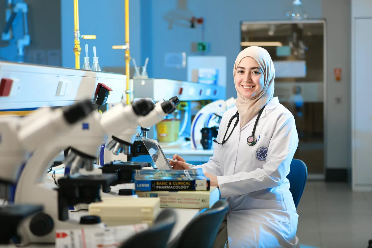 Pesquisador em laboratório analisando dados em gráficos e tabelas