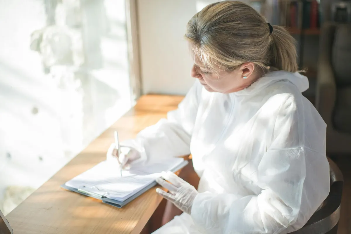 Pesquisadora olhando para tela de computador com expressão pensativa, representando o momento de receber um parecer