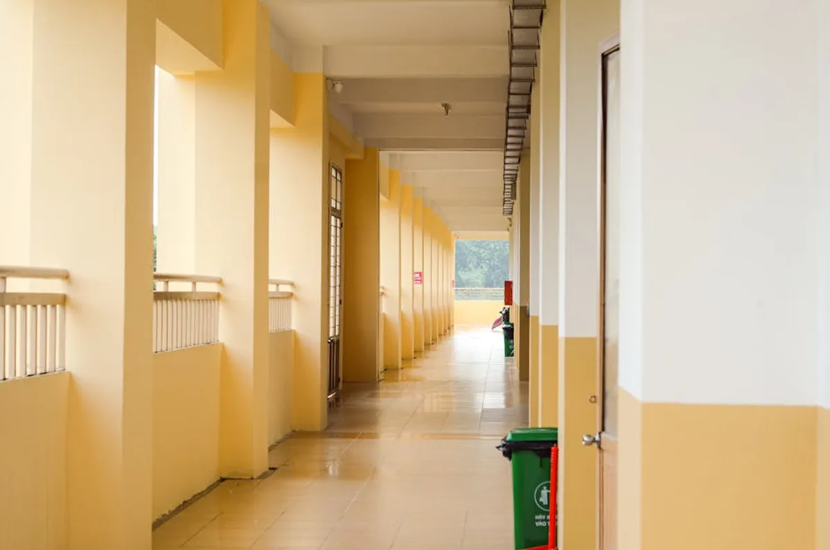 Corredor de universidade vazio com cartazes acadêmicos nas paredes