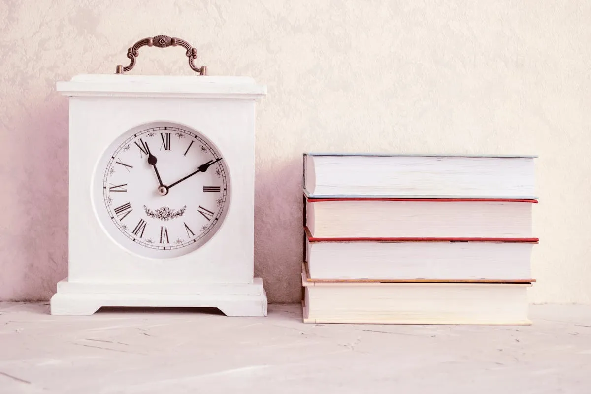 Pilha de artigos científicos sobre mesa com relógio ao fundo