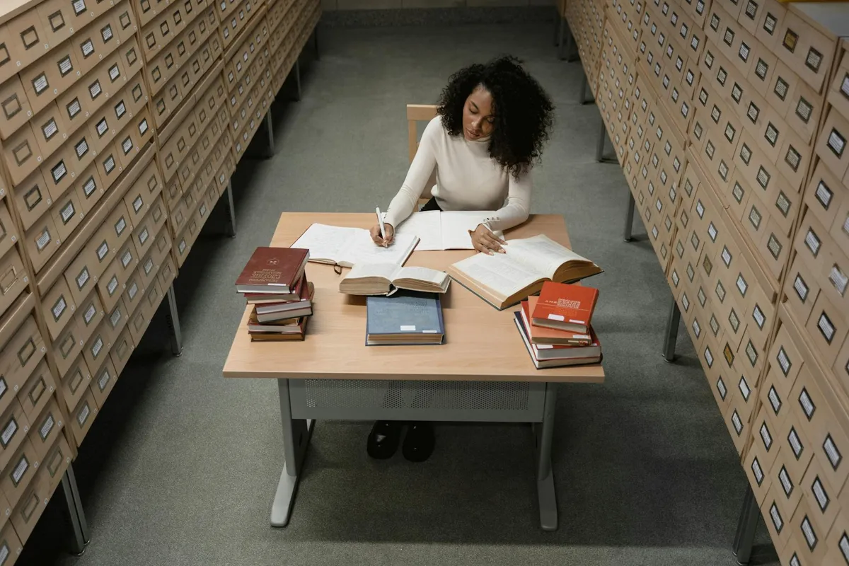 Pesquisadora fazendo busca bibliográfica no computador em biblioteca acadêmica