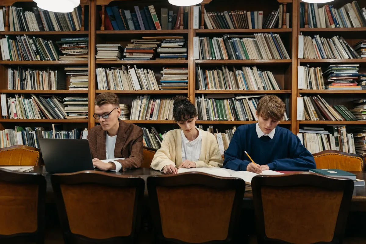 Pilha de livros acadêmicos abertos com notas adesivas coloridas em ambiente de biblioteca