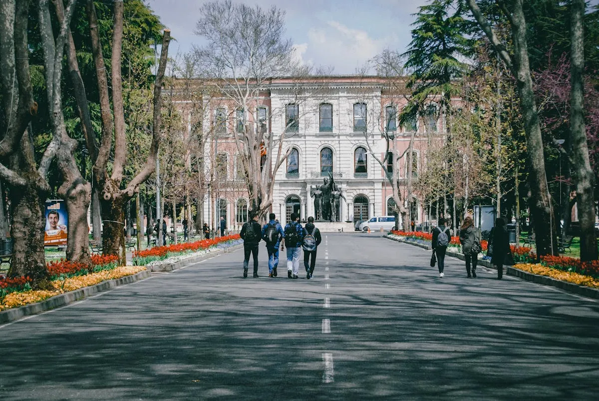 Fachada de universidade brasileira com estudantes caminhando em frente ao campus