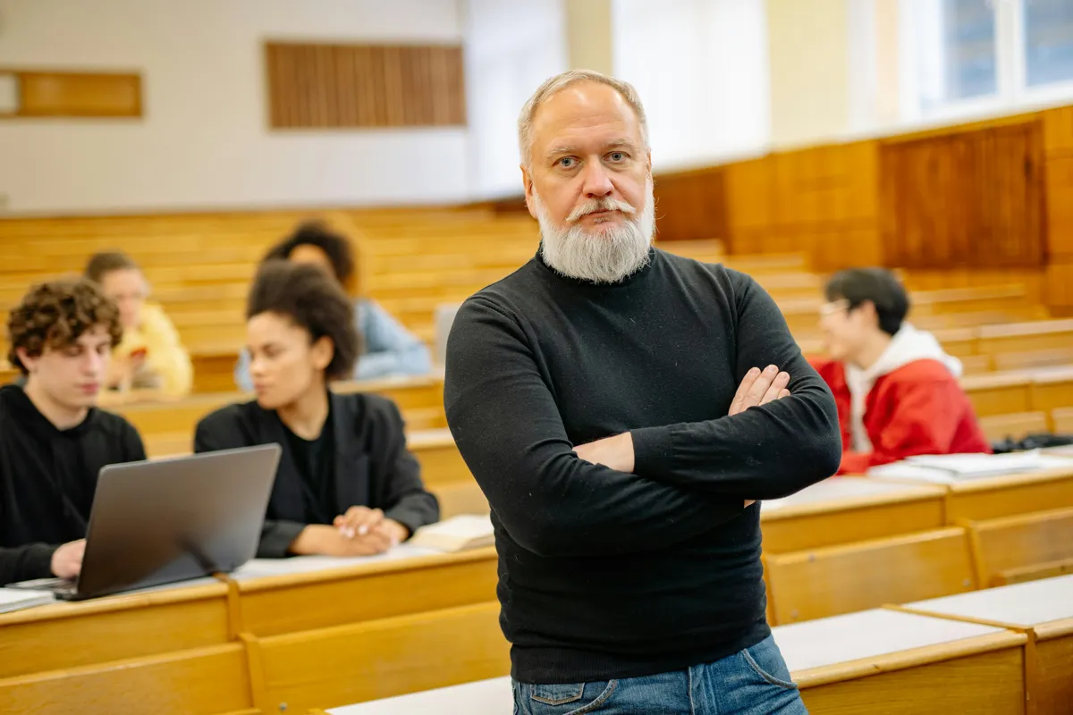 Estudante e professora conversando em mesa de reunião em ambiente universitário