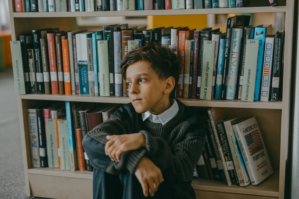 Estudante de pós-graduação sozinha em biblioteca ampla, olhando pela janela pensativa