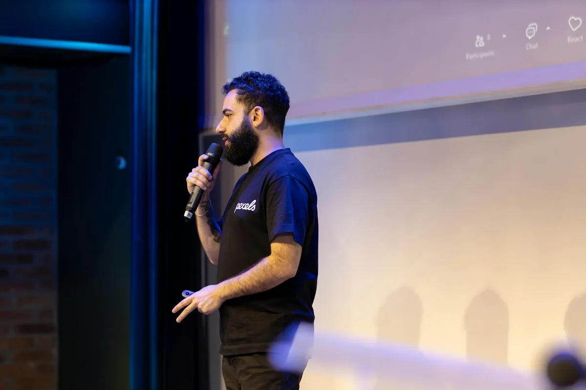 Pessoa apresentando trabalho em sala de aula para uma audiência universitária