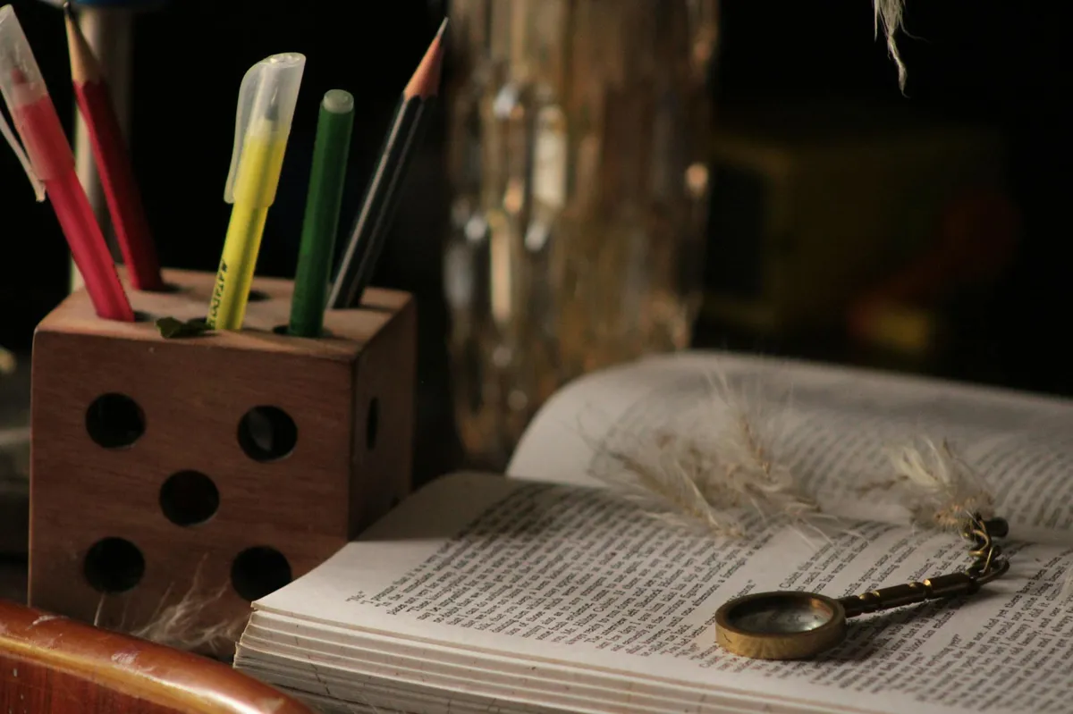 Livros de literatura e linguística abertos sobre mesa com caderno de anotações