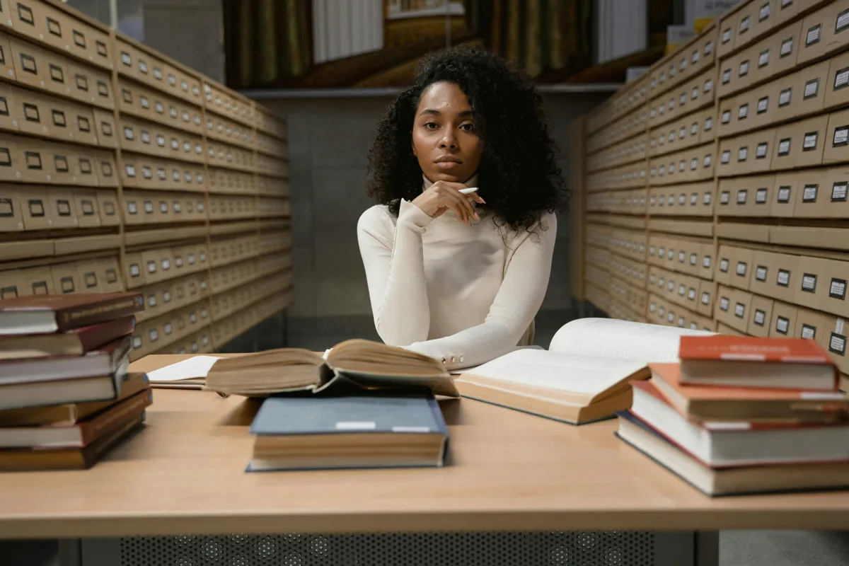 Estudante organizando livros e artigos para o referencial teórico do TCC