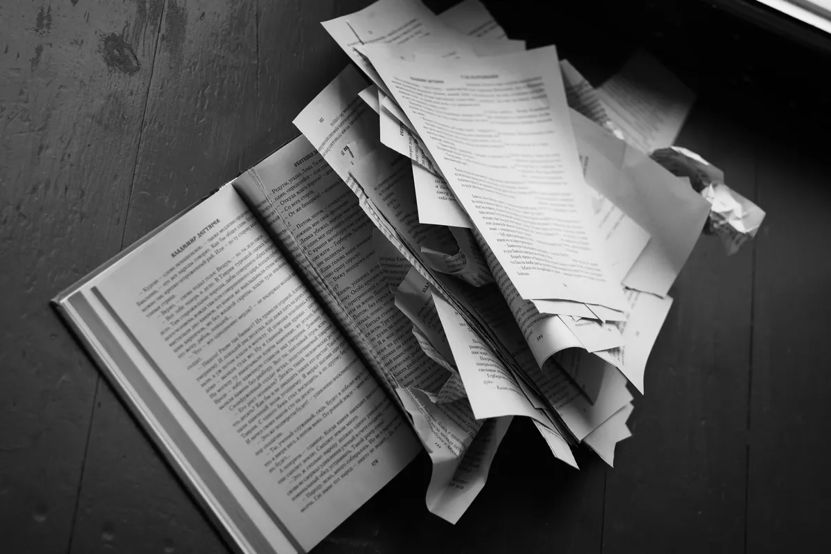 Doutoranda escrevendo tese em mesa com livros e cadernos de pesquisa