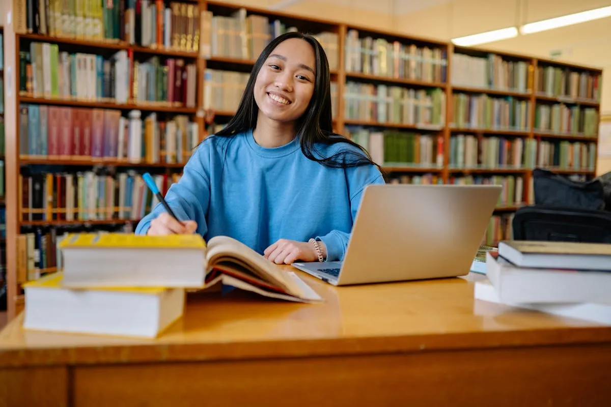 Pesquisadora estudando inglês com caderno e fones de ouvido em biblioteca