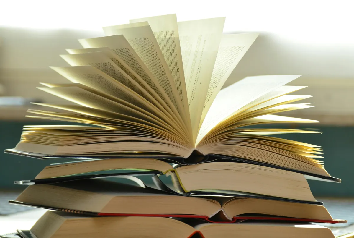 Livros científicos e caderno com normas de referências bibliográficas sobre mesa de estudos